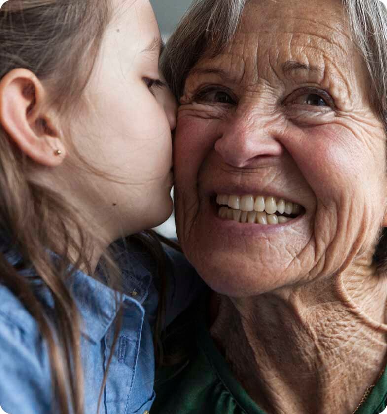 Niña besando en la mejilla a su abuela Niña besando en la mejilla a su abuela
